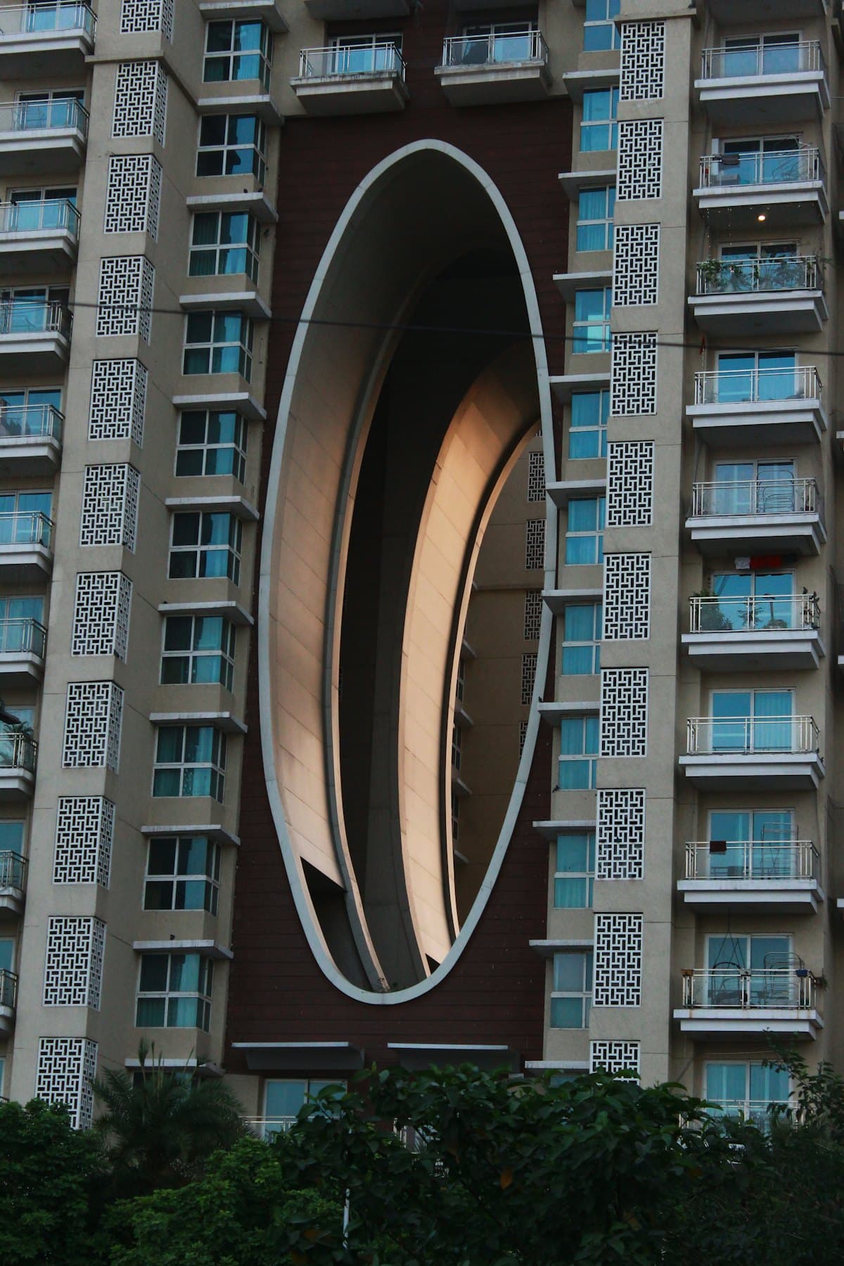 A residential tower with a sculpted oval facade